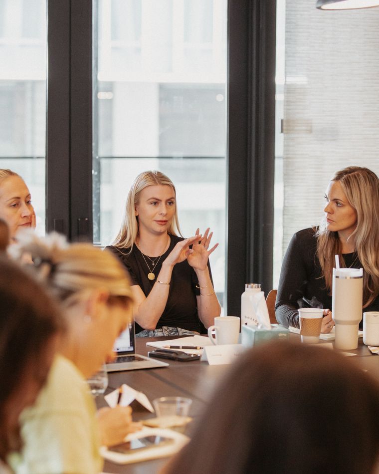 Natalie Ellis talking with women around a conference table